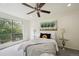 A bright bedroom with a large window, ceiling fan, and neutral decor at 9338 W Utah Pl, Lakewood, CO 80232