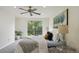 A bright bedroom with a large window, ceiling fan, neutral decor, and carpeting at 9338 W Utah Pl, Lakewood, CO 80232