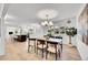 Open-concept dining area leading to a modern kitchen with a beautiful light fixture, hardwood floors, and decor at 3798 S Wabash St, Denver, CO 80237