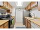 Galley kitchen featuring wooden cabinets and stainless steel refrigerator, offering a cozy cooking space at 14444 E Colorado Dr # 204, Aurora, CO 80012