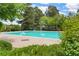 Community pool surrounded by mature trees and manicured shrubs at 14444 E Colorado Dr # 204, Aurora, CO 80012