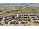 Wide aerial view showcasing a residential neighborhood with green spaces, streets, and mountain views at 6475 Umber Cir, Arvada, CO 80007