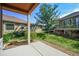 View of backyard featuring a green lawn, mature trees and a covered patio area at 6475 Umber Cir, Arvada, CO 80007