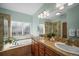 Bathroom featuring dual sinks, a bathtub, and a separate glass shower at 6475 Umber Cir, Arvada, CO 80007