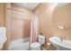 Well-lit bathroom featuring a shower-tub combo, classic vanity, and neutral tile work at 6475 Umber Cir, Arvada, CO 80007