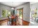 Bright dining room with hardwood floors, a stylish pendant light, and sliding glass doors to the backyard at 6475 Umber Cir, Arvada, CO 80007