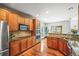 Modern kitchen boasts stainless steel appliances, wooden cabinets, granite countertops, and hardwood flooring with an open layout at 6475 Umber Cir, Arvada, CO 80007