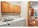 Practical laundry room with wood cabinets above a white washer and dryer set at 6475 Umber Cir, Arvada, CO 80007
