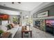 Spacious living room with fireplace flows into dining area and kitchen, filled with natural light from the windows and glass door at 6475 Umber Cir, Arvada, CO 80007