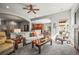 Inviting living room featuring a ceiling fan, neutral decor, and seamless flow to the dining and kitchen areas at 6475 Umber Cir, Arvada, CO 80007