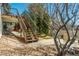 Exterior stairs leading to a backyard with a rock garden and mature landscaping at 2462 W Peakview Ct, Littleton, CO 80120
