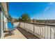 Balcony with blue chair and table overlooking scenic tree-lined view at 2462 W Peakview Ct, Littleton, CO 80120