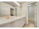 Bright bathroom with double sinks, white cabinets, and a view into the shower/tub area at 2462 W Peakview Ct, Littleton, CO 80120