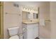 Cozy bathroom featuring a vanity with a single sink, gold fixtures, and a standard toilet at 2462 W Peakview Ct, Littleton, CO 80120