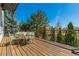 Outdoor deck area featuring dining table, with lush greenery and serene ambiance at 2462 W Peakview Ct, Littleton, CO 80120