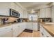 Bright kitchen featuring white cabinetry, stainless steel appliances, and tile countertops at 2462 W Peakview Ct, Littleton, CO 80120
