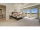Light-filled main bedroom features a tray ceiling, ceiling fan, and sliding glass doors to a balcony at 2462 W Peakview Ct, Littleton, CO 80120
