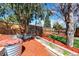Landscaped backyard with garden beds and mature trees, offering a serene and private outdoor space at 426 Jupiter Dr, Lone Tree, CO 80124