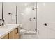 Bright bathroom featuring modern vanity with white quartz countertop and a tiled shower with glass enclosure at 1344 N Knox Ct, Denver, CO 80204