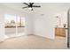Bright bedroom with a ceiling fan, carpeted floors, sliding glass doors, and an ensuite bathroom at 1344 N Knox Ct, Denver, CO 80204