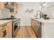 Modern kitchen featuring wood cabinets, quartz countertops, and stainless steel appliances at 1344 N Knox Ct, Denver, CO 80204