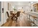 Bright living room featuring wood floors, round glass table, white walls, and light-filled windows at 1344 N Knox Ct, Denver, CO 80204