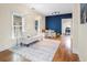 Open living room with hardwood floors, white couch, and a blue accent wall at 2537 Chase St, Edgewater, CO 80214