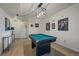 Spacious finished basement features a pool table with decorative lights and sports memorabilia at 7895 S Zante Ct, Aurora, CO 80016