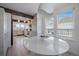 Bright dining area with modern light fixture, large windows, and hardwood floors at 7895 S Zante Ct, Aurora, CO 80016