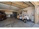 Clean, organized garage featuring a golf cart, storage cabinets, and ample space at 7895 S Zante Ct, Aurora, CO 80016