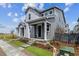 Inviting two-story home with a covered front porch, green lawn, and tasteful landscaping at 14101 Deertrack Ln, Parker, CO 80134
