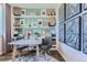 Bright home office with a stylish desk, two chairs, wall art, and built-in shelving and storage at 14101 Deertrack Ln, Parker, CO 80134