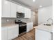 Modern kitchen features white cabinetry, stainless appliances, gas range and island with a sink at 14101 Deertrack Ln, Parker, CO 80134