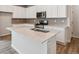 Modern kitchen features an island with quartz countertops and stainless steel appliances at 14101 Deertrack Ln, Parker, CO 80134