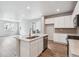 Modern kitchen features white cabinetry, stainless appliances, and island with sink open to living space at 14101 Deertrack Ln, Parker, CO 80134