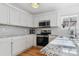 Modern kitchen with white cabinets and granite countertops at 22382 E Mercer Pl, Aurora, CO 80018