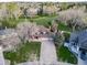 Aerial view of a home with an expansive yard, mature trees, and neighborhood in the background at 20838 Parliament Ct, Parker, CO 80138