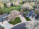 An elevated view of a well-landscaped house featuring a long driveway and mature trees at 20838 Parliament Ct, Parker, CO 80138