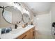 Bathroom featuring double sinks, wood cabinetry, and a shower-tub combo at 20838 Parliament Ct, Parker, CO 80138