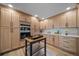Well-lit kitchen featuring wooden cabinets, stainless steel appliances, and a mobile kitchen island at 20838 Parliament Ct, Parker, CO 80138