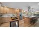 An open kitchen includes wood cabinets, stainless steel appliances, island with counter seating, and wood flooring at 20838 Parliament Ct, Parker, CO 80138