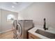 Bright laundry room featuring modern machines, ample counter space, a sink, and a stylish window at 20838 Parliament Ct, Parker, CO 80138