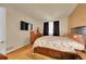 Cozy bedroom featuring light hardwood floors, a large bed, neutral walls, and natural light at 12943 Lafayette St # F, Thornton, CO 80241