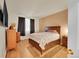 Cozy bedroom featuring light hardwood floors, a large bed, neutral walls, and natural light at 12943 Lafayette St # F, Thornton, CO 80241
