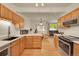 Functional kitchen layout with wood cabinets, stainless steel appliances, and open access to dining area at 12943 Lafayette St # F, Thornton, CO 80241