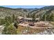 Aerial view of a stunning mountain home with a tile roof, sprawling grounds, and scenic surroundings at 290 Skyhill Dr, Evergreen, CO 80439