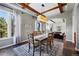 Elegant dining room with a wooden table, exposed beams, and lots of natural light at 290 Skyhill Dr, Evergreen, CO 80439
