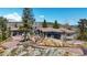 Stunning exterior of mountain home featuring a tiled roof, stone accents, and lush landscaping at 290 Skyhill Dr, Evergreen, CO 80439