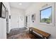 Welcoming foyer with slate tile flooring, wooden bench, and lots of natural light at 290 Skyhill Dr, Evergreen, CO 80439