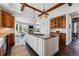 Open-concept kitchen with island, wooden beams, and views into the living area at 290 Skyhill Dr, Evergreen, CO 80439